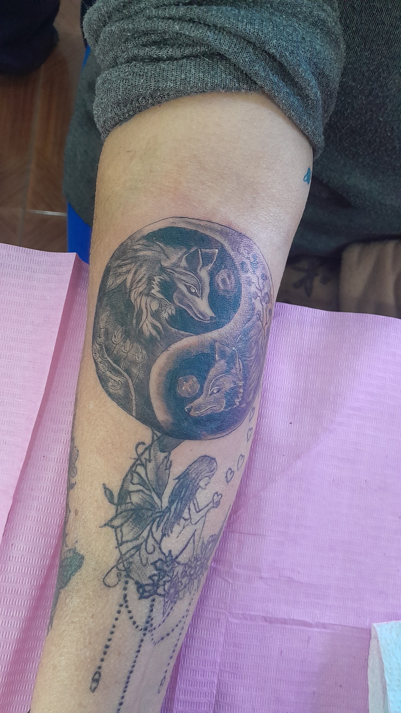 Tatuaje Black and Grey de lobos en Yin Yang con hada, en antebrazo, por Ares Tattoo