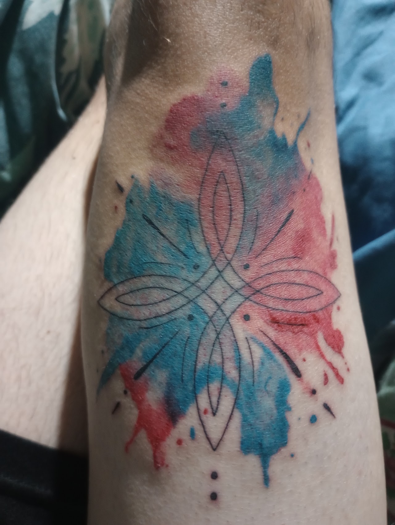 Tatuaje geométrico con técnica watercolor (acuarela) en antebrazo, por Ares Tattoo